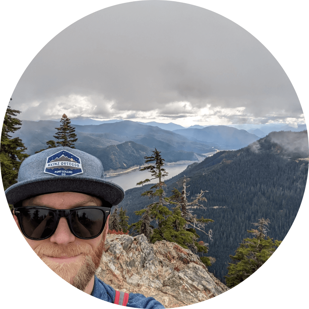 Picture of Dick's Drive-In Employee Stefan Bennett on the top of a mountain with a valley in the background. Sky is overcast.